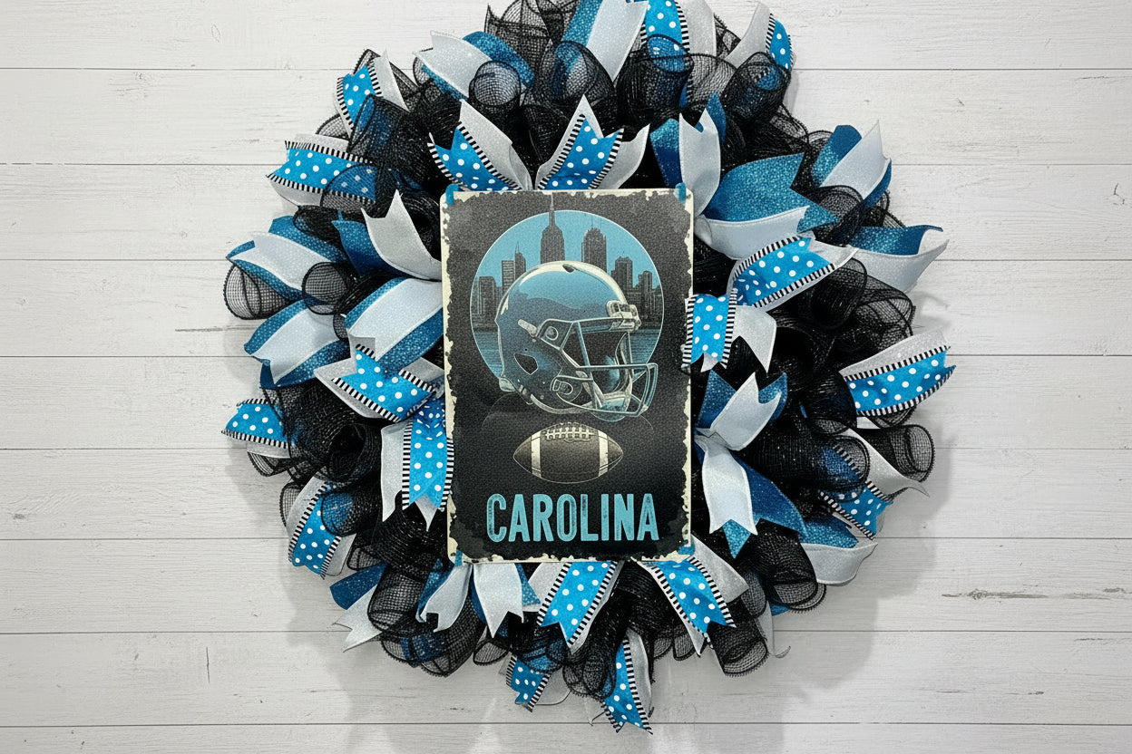Handmade Carolina football wreath featuring black, blue, and white mesh ribbon with a helmet and football sign, perfect for sports fan front door decor.