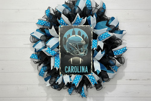Handmade Carolina football wreath featuring black, blue, and white mesh ribbon with a helmet and football sign, perfect for sports fan front door decor.