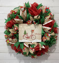 Handmade Christmas wreath with red and green mesh ribbon, featuring a vintage bicycle ‘Tis the Season’ sign for festive holiday front door decor.