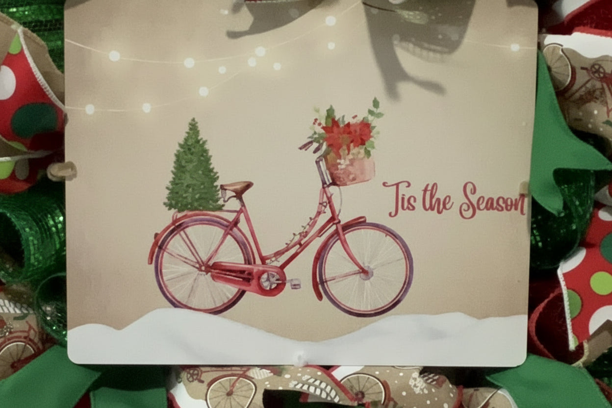 Handmade Christmas wreath with red and green mesh ribbon, featuring a vintage bicycle ‘Tis the Season’ sign for festive holiday front door decor.
