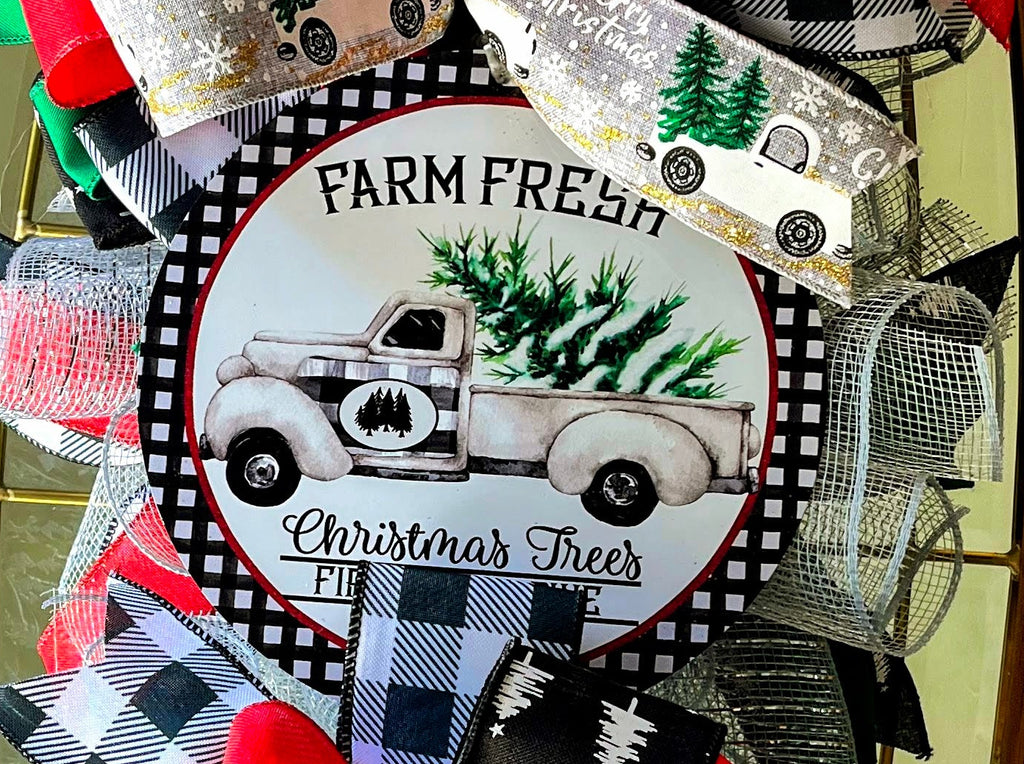 Handmade vertical Christmas swag featuring a vintage farmhouse truck with Christmas tree, accented with red, green, and buffalo check ribbon for front door decor.
