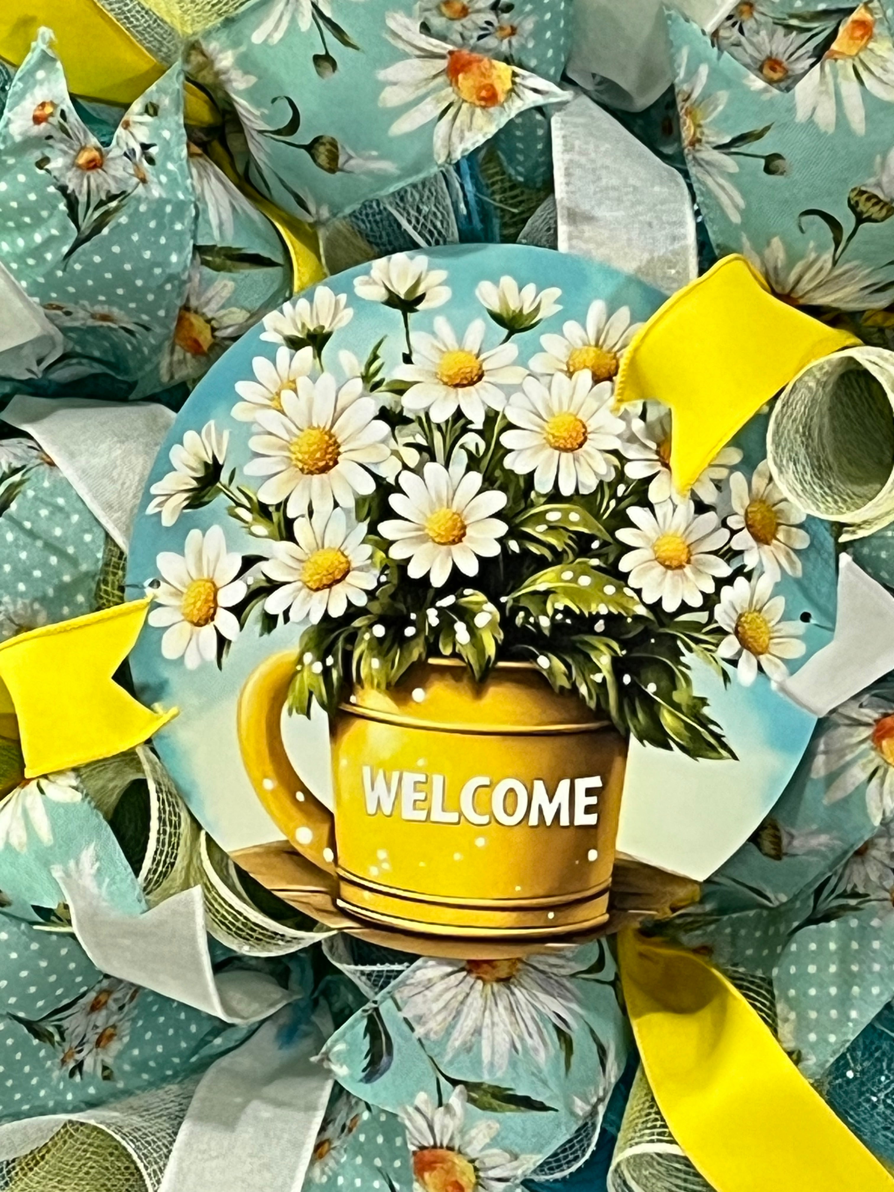 Handmade spring and summer wreath with blue and yellow mesh ribbon, featuring a daisy-filled welcome sign for cheerful front door decor.