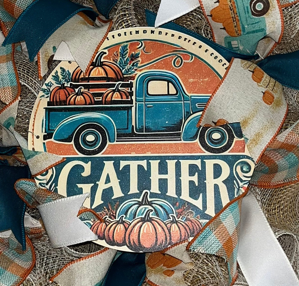 Handmade farmhouse fall wreath with burlap mesh, teal and white ribbon, featuring a vintage truck and ‘Gather’ sign for autumn front door decor.