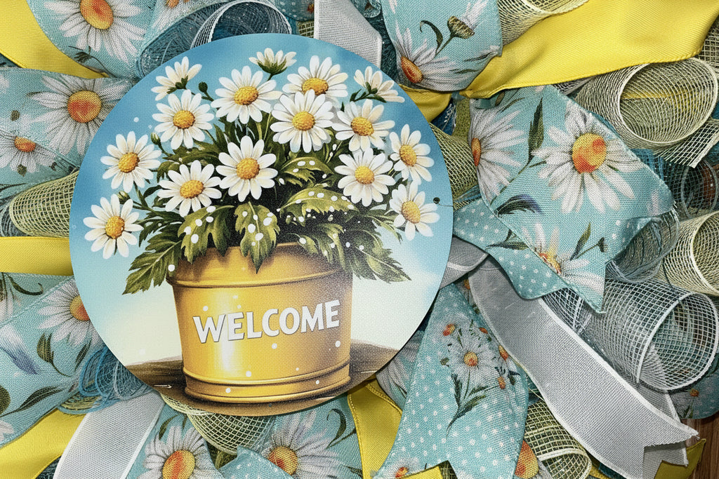 Handmade spring and summer wreath with blue and yellow mesh ribbon, featuring a daisy-filled welcome sign for cheerful front door decor.