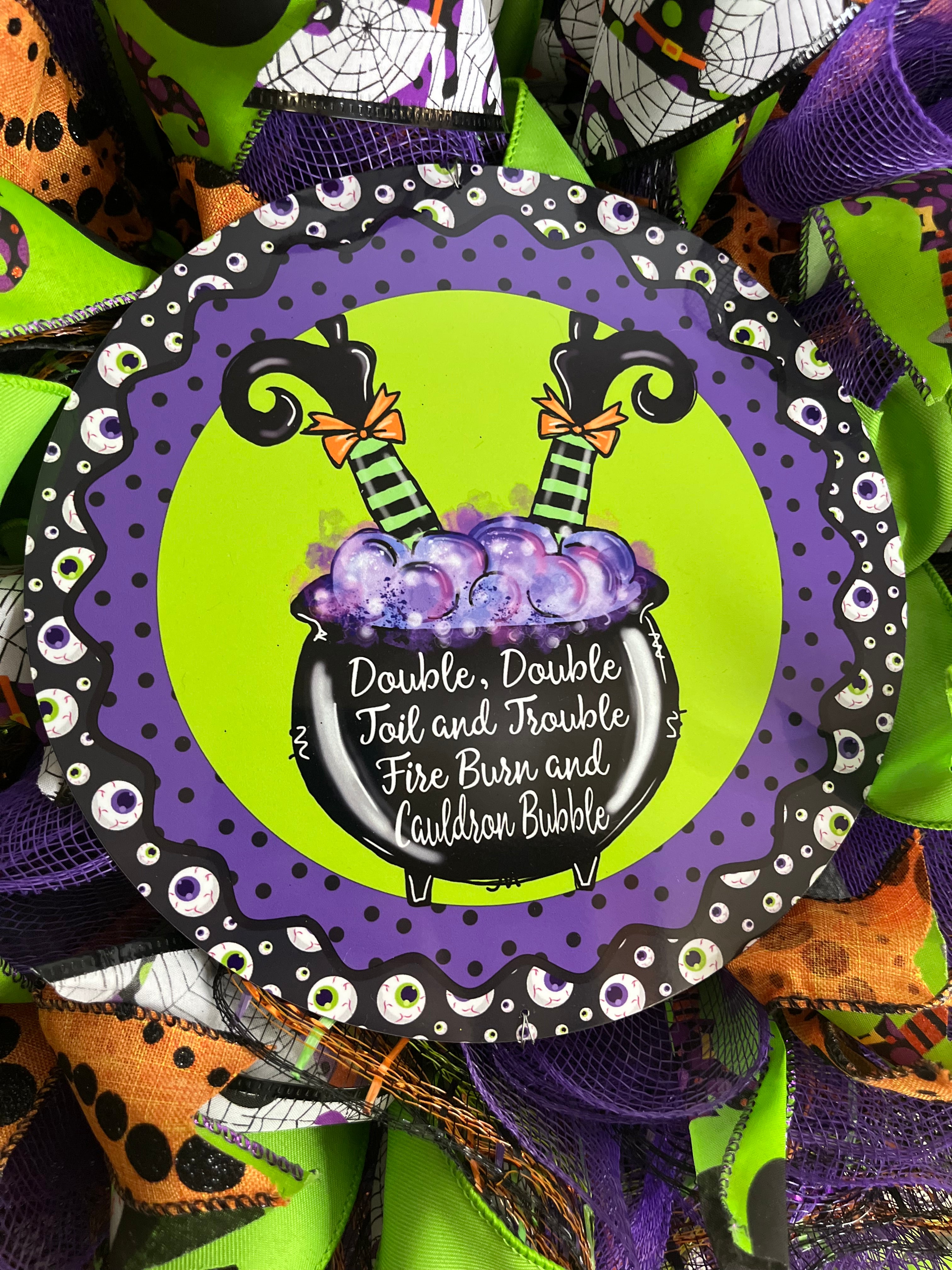 Halloween-themed decorative wreath with colorful ribbons and a central circular design.
