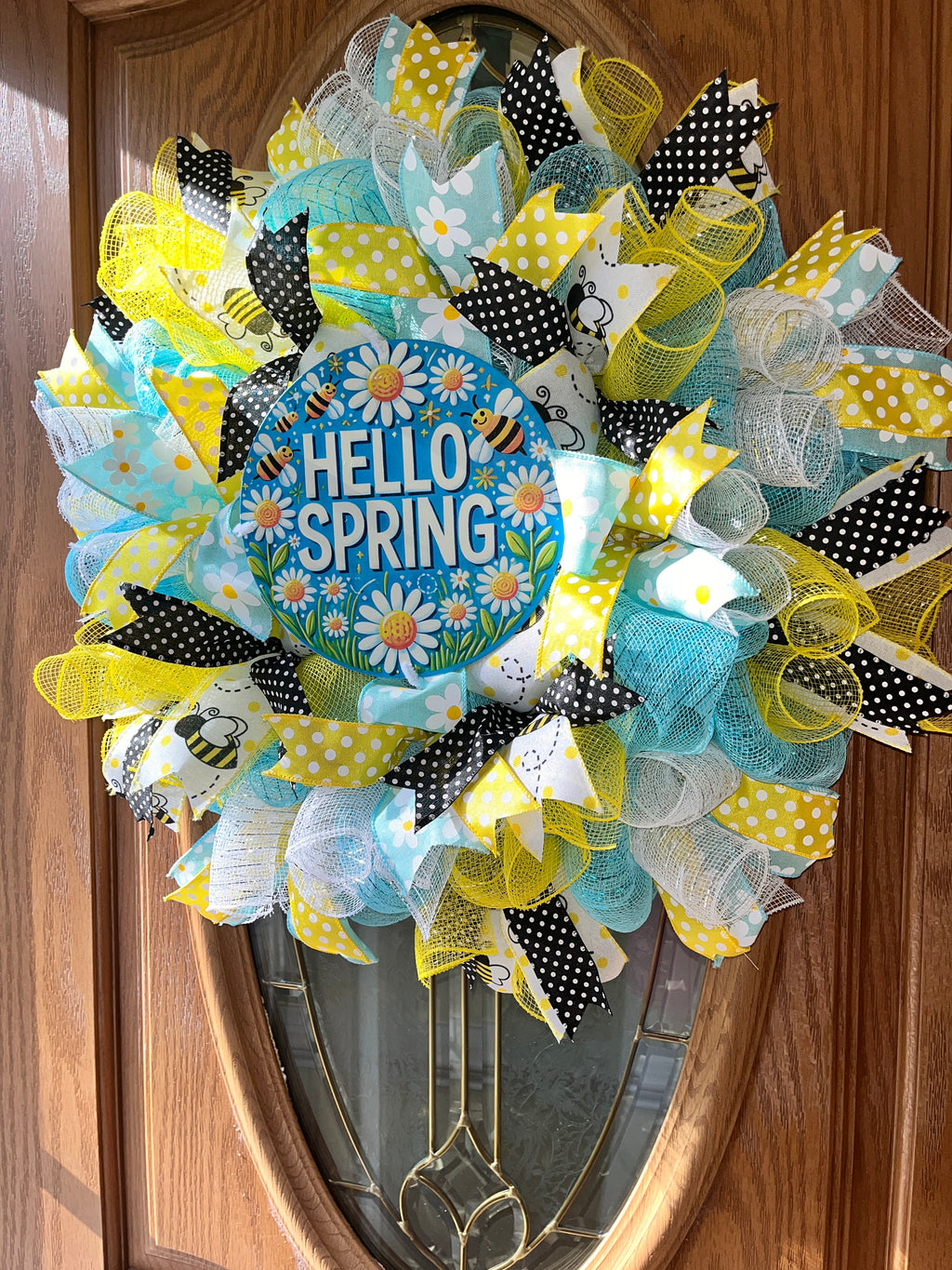 Decorative wreath with 'Hello Spring' text on a wooden door
