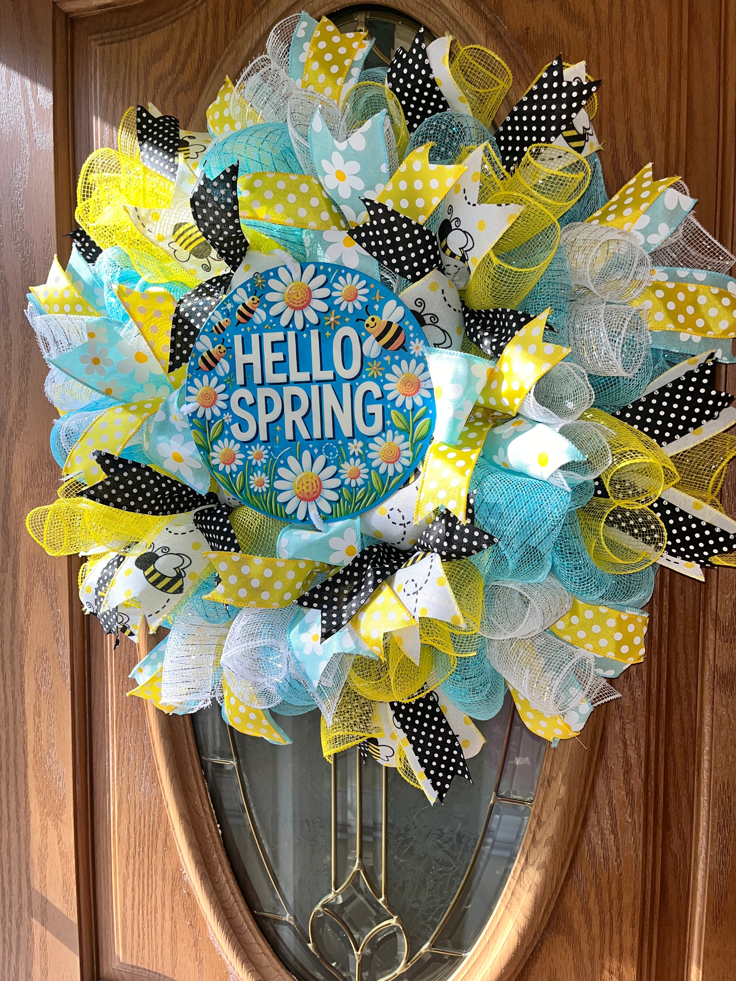 Decorative wreath with 'Hello Spring' text on a wooden door