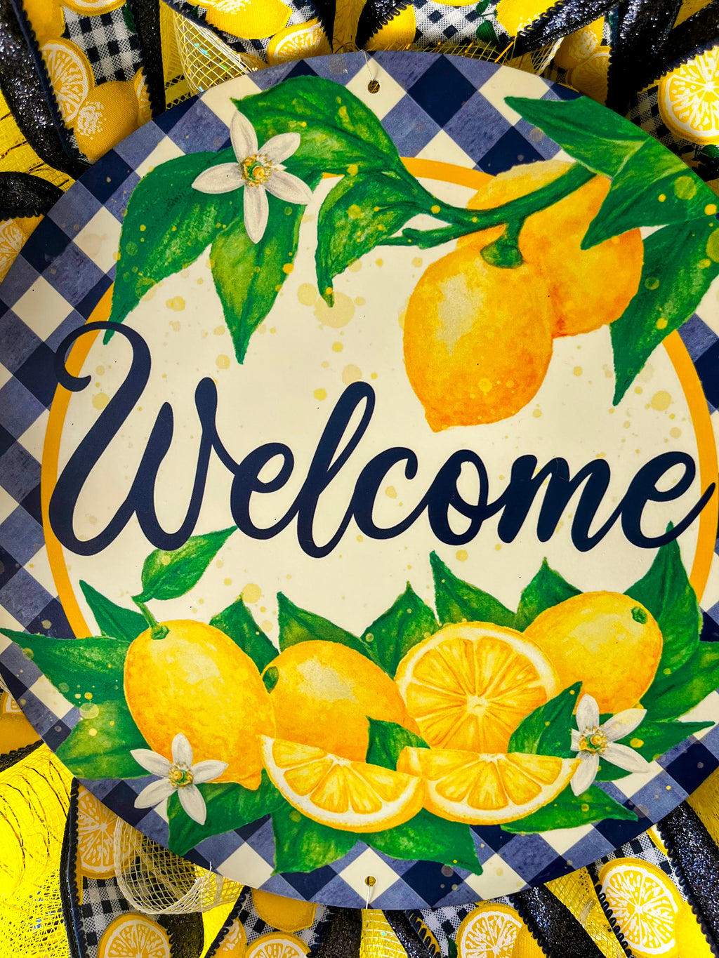 Handmade lemon wreath with bright yellow mesh and blue accents, featuring a ‘Welcome’ sign and citrus design for summer farmhouse front door decor.
