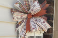 Handmade decorative bow with 'Thankful' text on a door leaner.